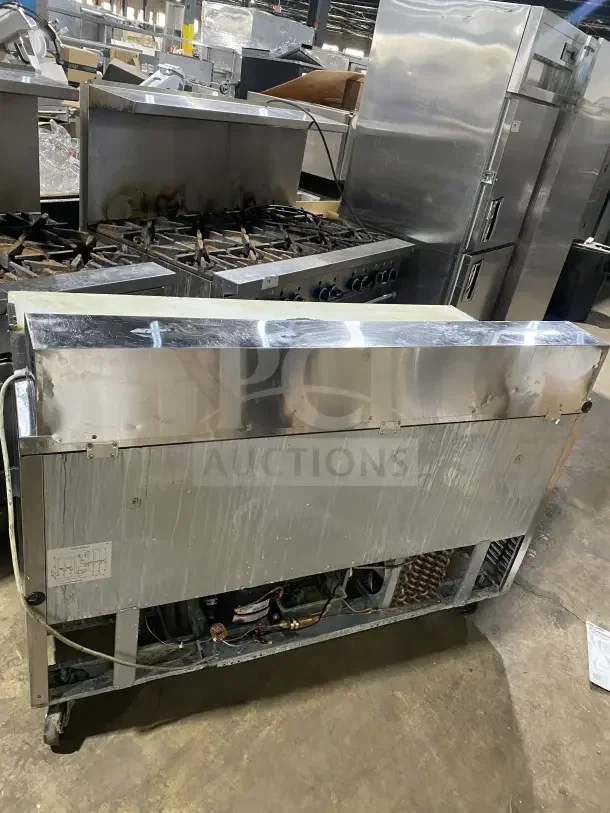 Turbo Air TST-60SD refrigerated prep table, stainless steel, two doors, includes cutting board and chrome rack, on casters.