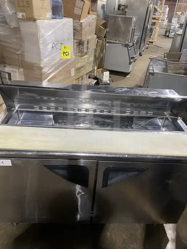 Turbo Air TST-60SD 2-door stainless steel prep table with cutting board and chrome rack, on casters, 115V.