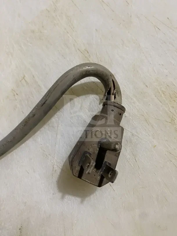Close-up of a frayed power cord and plug on a Turbo Air prep table, highlighting wear and need for repair.