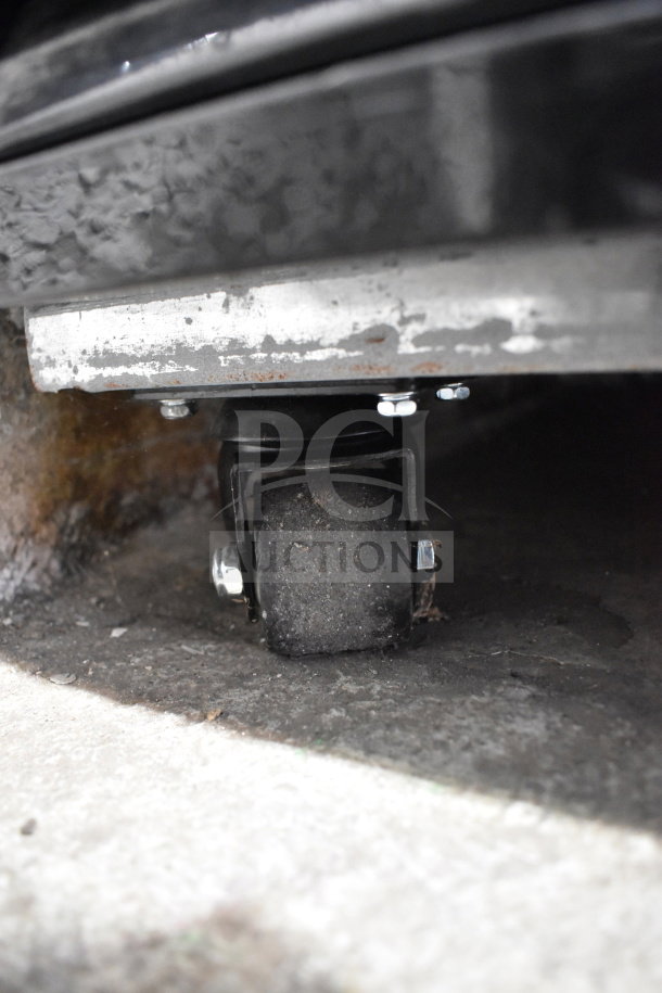 Migali C-72RM-HC reach-in cooler caster detail, showing a sturdy commercial wheel mounted on a metal base.