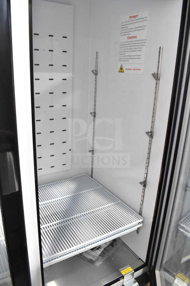 Brand new 2022 Migali C-72RM-HC commercial 3-door cooler, on casters, 115V, 1 phase. Interior shelving and safety labels visible.
