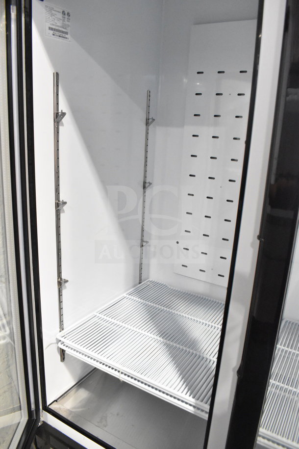 Migali C-72RM-HC 3 Door Reach-In Cooler, brand new scratch and dent, interior shelving visible, on commercial casters.