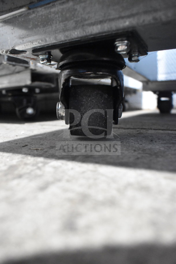 Commercial caster on 2023 Migali C-72RM-HC Cooler, brand new condition, close-up view.