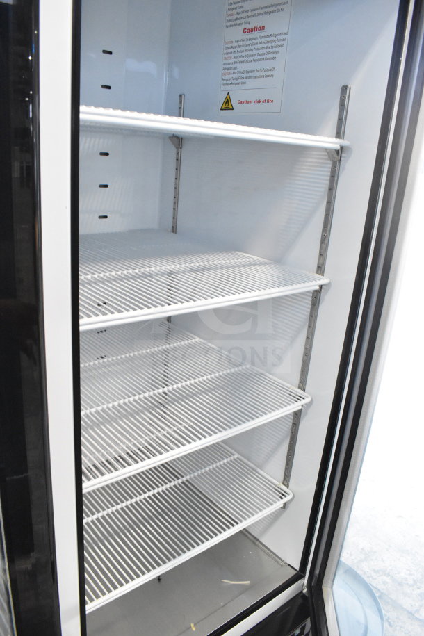 Brand new Migali C-72RM-HC 3-door cooler merchandiser with commercial casters; 115V, 1-phase, interior shelves visible.