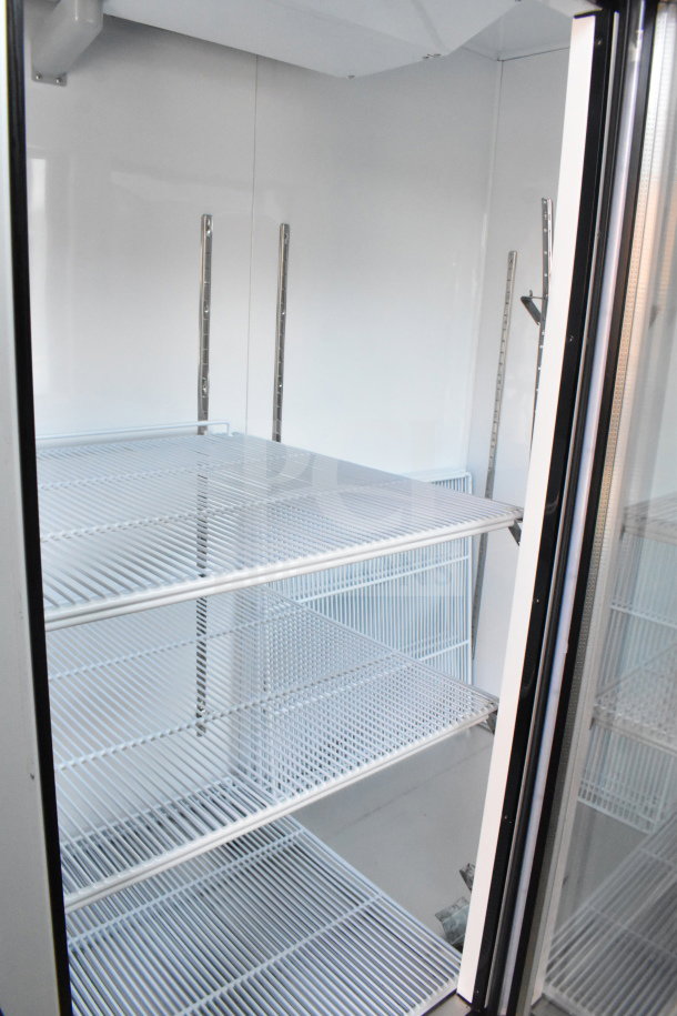 Brand new 2019 Migali C-72FM commercial 3-door reach-in freezer merchandiser with shelves visible inside.