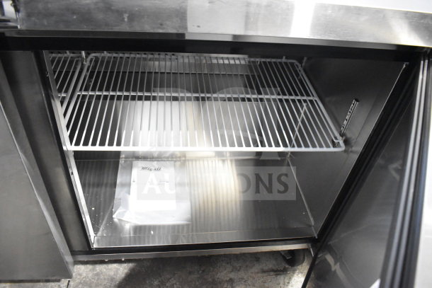 Brand new Migali C-U60F-HC commercial 2-door undercounter freezer on casters, 115V, 1 phase, serial visible, includes shelving.