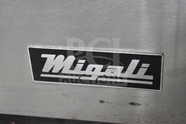 Migali logo on stainless steel surface of a 2017 C-U60F-HC commercial undercounter freezer with minor scratches.
