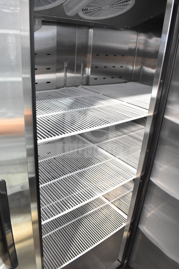 Brand new Migali C-3R-HC 3-door reach-in cooler interior, showing clean shelves and stainless steel finish.