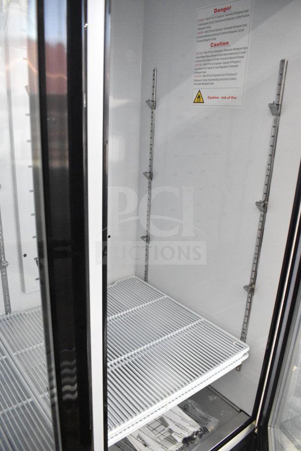 alt="Brand new 2019 Migali C-3R-HC commercial 3-door reach-in freezer on casters. Model C-72FM-HC with shelves and interior warning label."