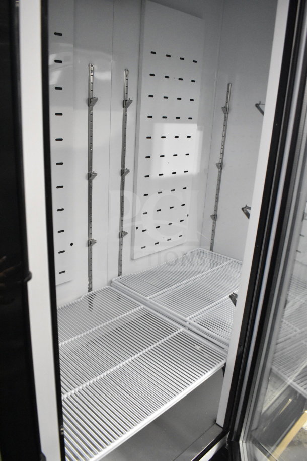2022 Migali C-72FM-HC 3-door freezer merchandiser interior view, featuring adjustable metal shelving. Brand new condition.
