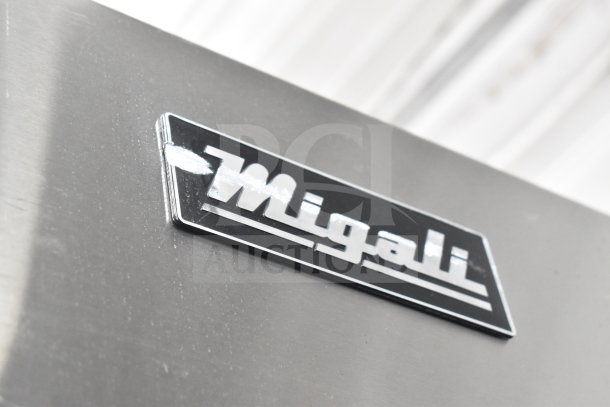 Alt text: Migali C-3R logo on a commercial reach-in freezer. Scratch and dent condition, 3-door, on casters.