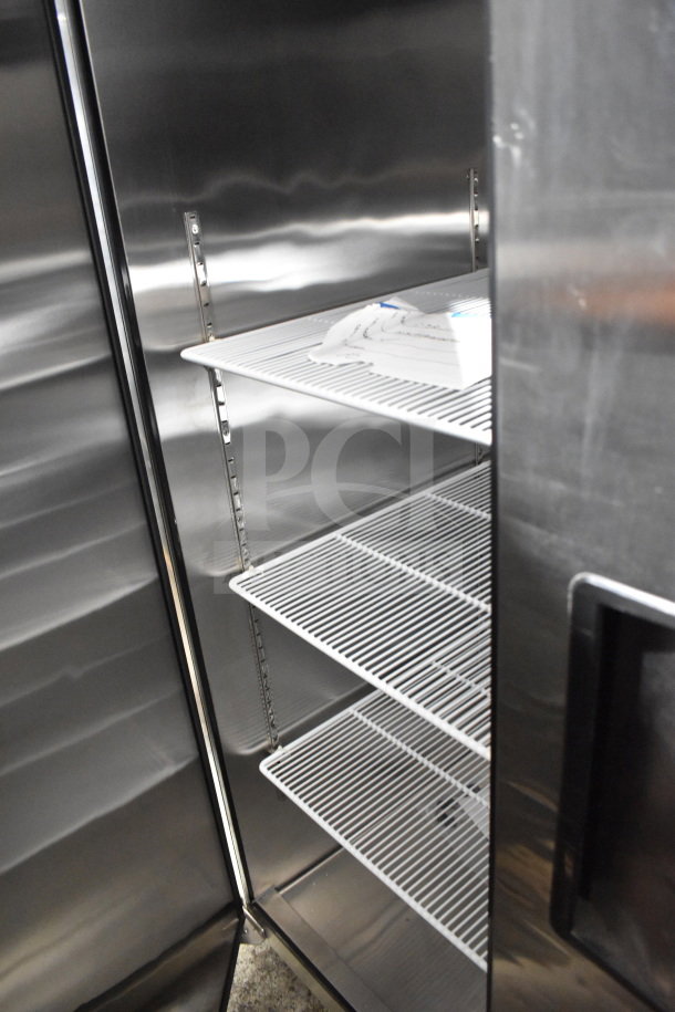 Migali C-3R three-door reach-in freezer, scratch and dent condition, stainless steel, with shelves, on commercial casters.