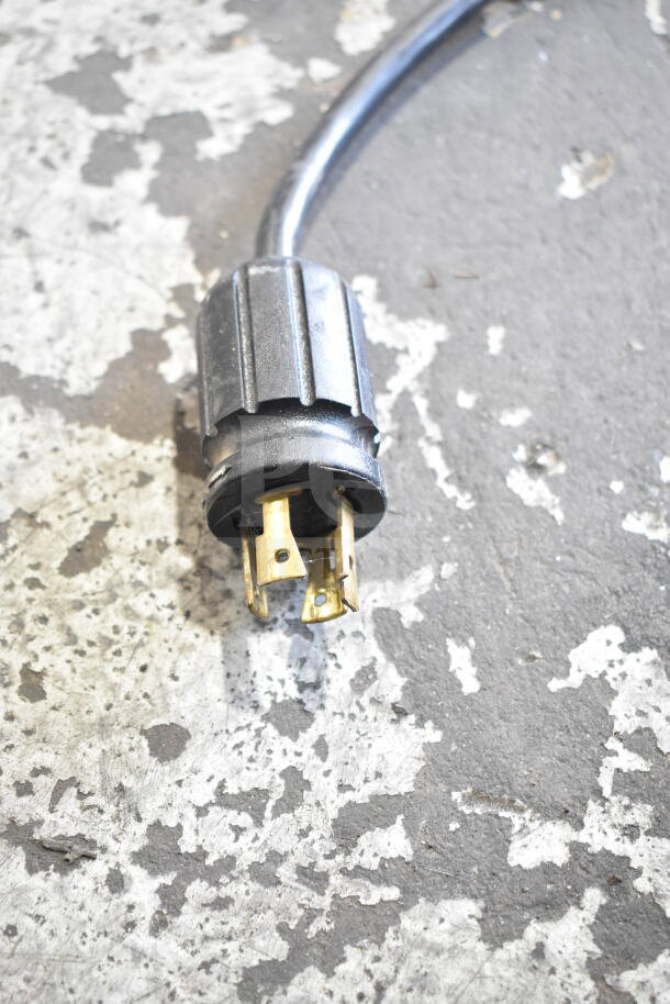 Power plug for 2016 True GDM-72F-HC freezer merchandiser, 115/208-230V, 1 phase, shows metal prongs and black casing.
