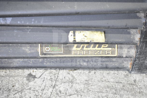 True GDM-72F-HC commercial freezer label, "natural refrigerant" marking, metal surface with visible wear.