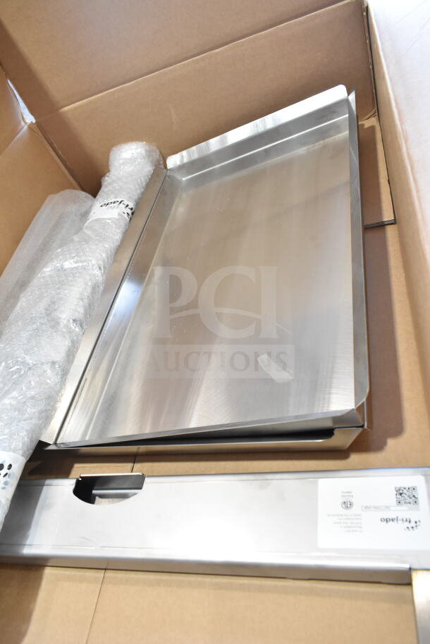 Brand new Fri-jado Spit Trolley Large in box, stainless steel, minor scratches. Markings show brand and specifications.