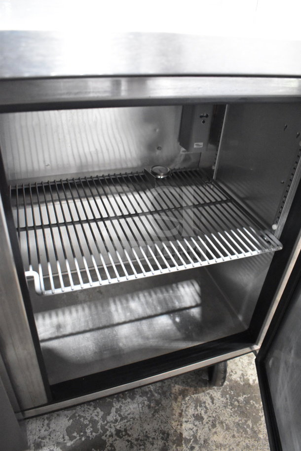 True TUC-72 commercial 3-door undercounter cooler, open view of interior shelf, on casters, 115 volts, 1 phase.