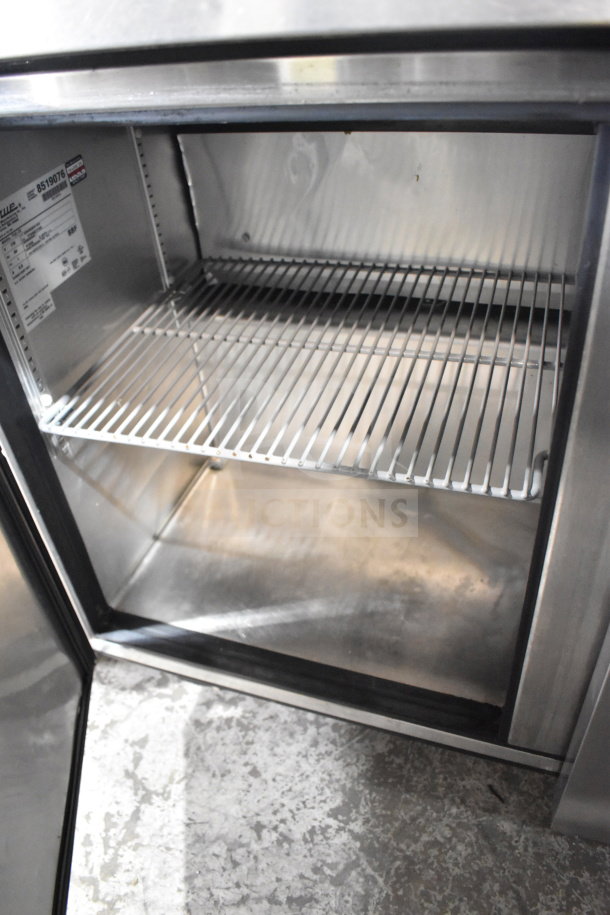 True TUC-72 Commercial 3 Door Undercounter Cooler on casters. Stainless steel, 115V, 1 phase. Interior label visible.