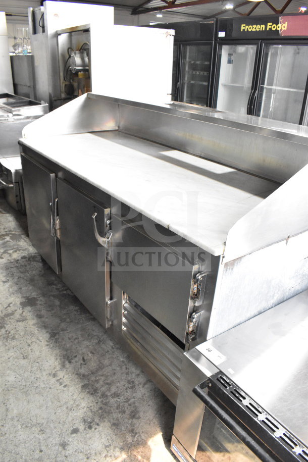 Commercial 3-door cooler with stone countertop and casters. Stainless steel finish. Good condition for restaurant use.
