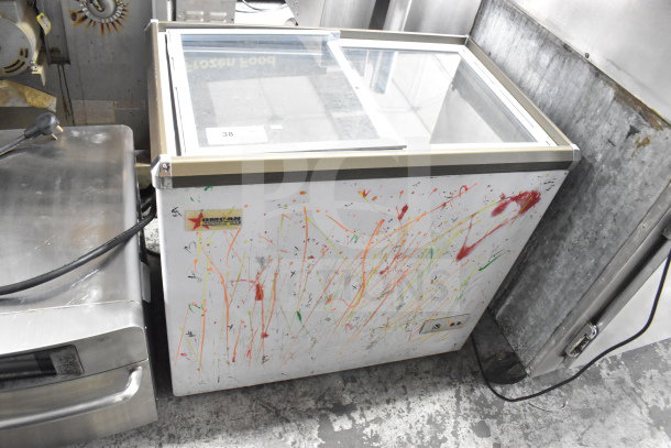 Omcan XS-200 Chest Freezer Merchandiser with glass top, 110 Volts, 1 Phase. Visible paint splatter and Omcan logo.