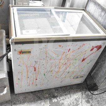 Omcan XS-200 Chest Freezer Merchandiser with glass top, 110 Volts, 1 Phase. Visible paint splatter and Omcan logo.