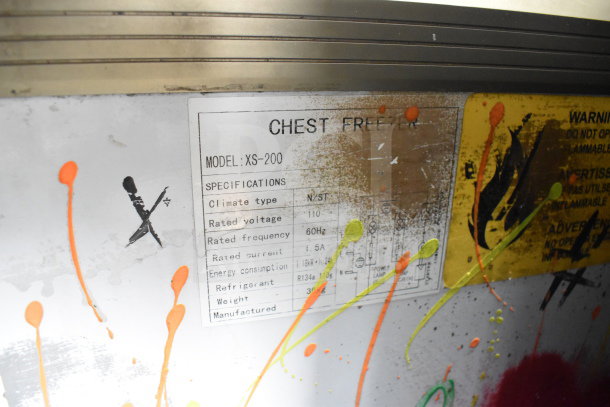 Omcan XS-200 Chest Freezer Merchandiser label, 110V, 1 phase, specifications and warning. Paint splatters on surface.