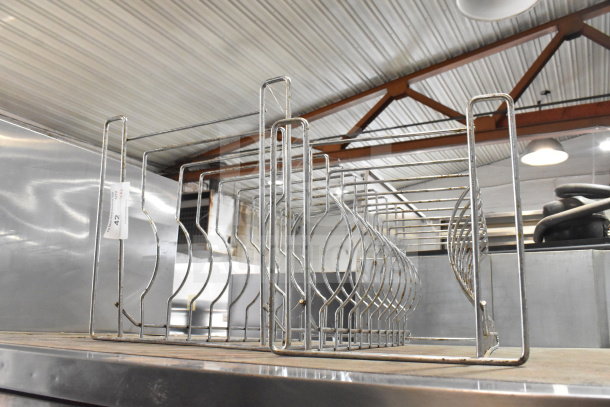 2 countertop pizza pan racks in metal, stackable design, gently used. Auction label "42" attached.