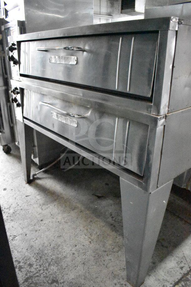 Bakers Pride E541 commercial 2-deck pizza oven, stainless steel, on metal legs. 208V, 3-phase. Sturdy, ideal for high-volume use.