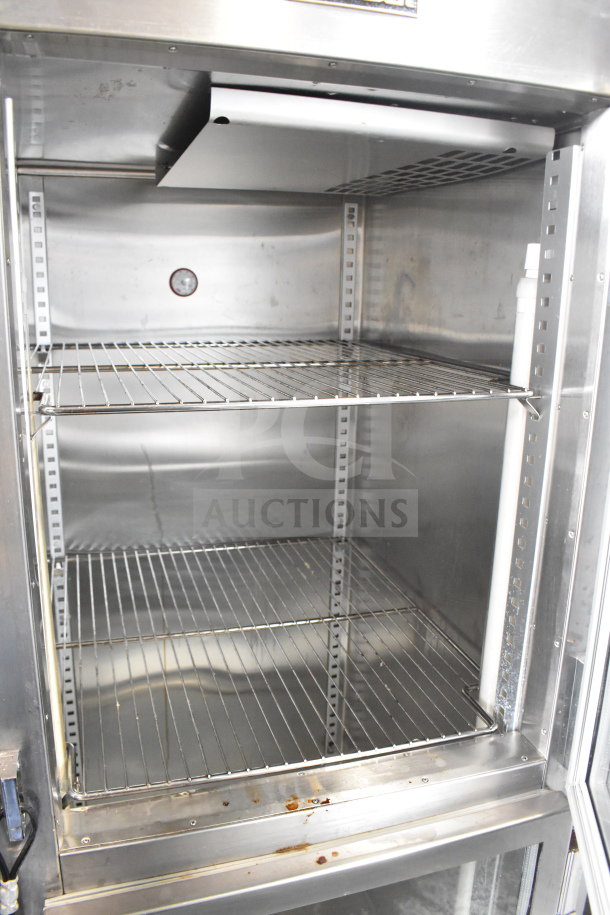 Traulsen RHT132WUT-HHG stainless steel glass half-door fridge, 24.2 Cu. Ft., on commercial casters, clean interior.