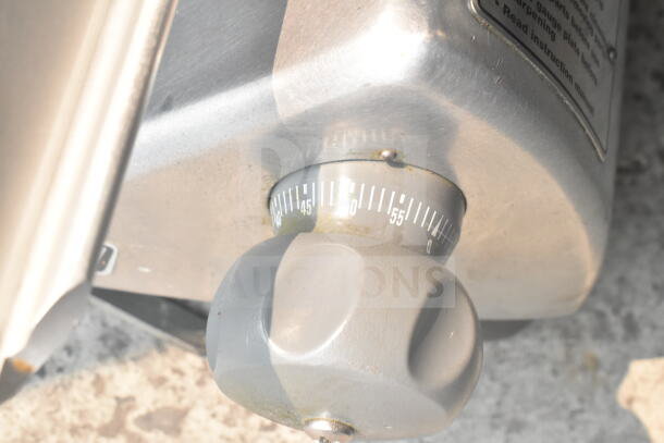 Hobart HS6N slicer control knob detail, showing numerical settings. Stainless steel, slight wear visible.