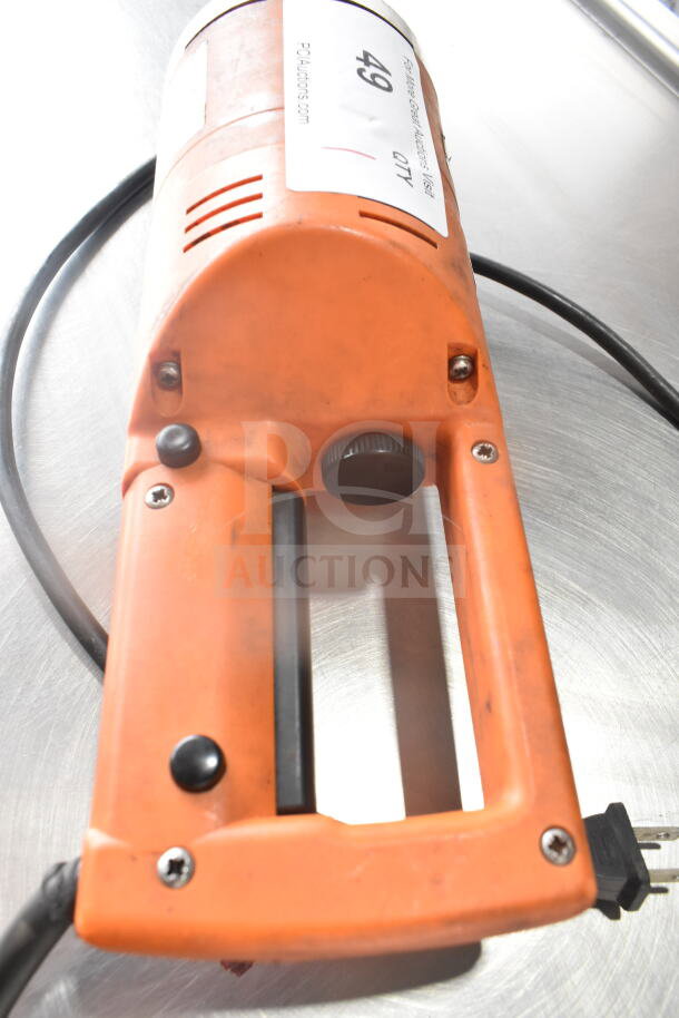 Dynamic MF90 Commercial Immersion Blender, 115V, 1 Phase, orange casing, visible auction label, sturdy black handle.