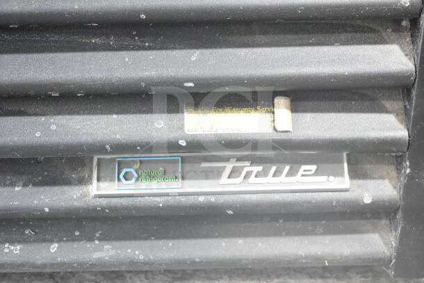 2019 True GDM-72-HC commercial cooler, black exterior, natural refrigerant label, 115V, 1 phase, visible dust and wear.
