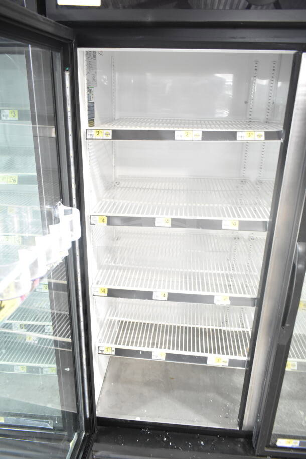 2019 True GDM-72-HC commercial 3-door reach-in cooler, open view showing interior shelving. Model tags visible.