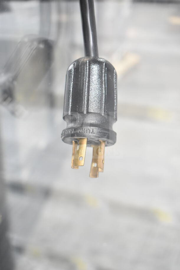 Close-up of a power plug for a 2019 True GDM-72F-HC commercial freezer, showing prongs and brand marking.