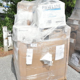 Pallet of 17 new scratch and dent items including carryout bags, meat trays, towels, teaspoons, wrapped in plastic.