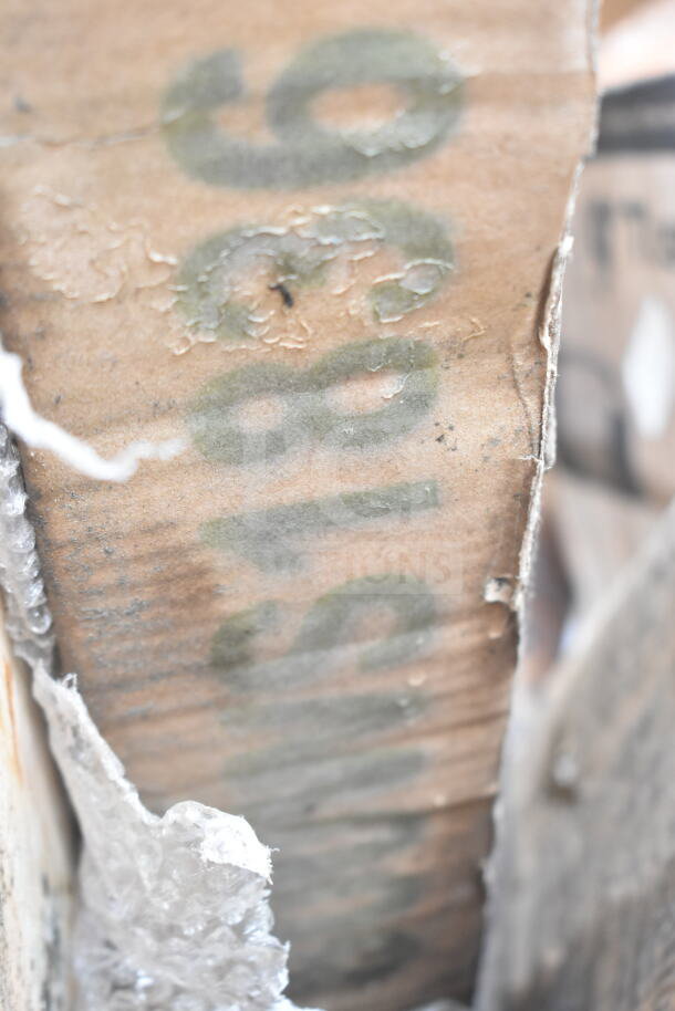 Close-up of a cardboard box with visible wear and faded numbers. Part of a lot including a shelf, pot rack, and grease trap.