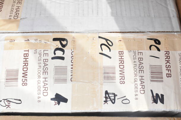 Cardboard box with labels showing "TABLE BASE HARD" and codes like "BRHRDW8." Marked "PCI" multiple times. Scratched condition.
