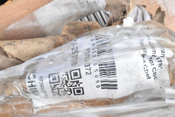 Barcode and QR code on packaging for new scratch and dent items including mobile ice bin and table. Tags partially visible.