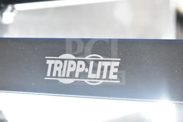 Tripp Lite bracket with visible logo, part of a lot including an Onn monitor and Sensormatic AMB-9010-IPS.