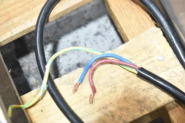 Alt text: Exposed wires of a new Estella ECEM2/N2 espresso machine on a wooden pallet, showing minor scratches.
