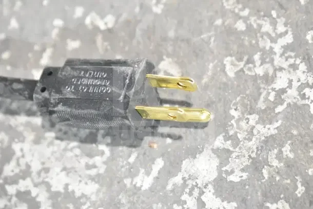 Close-up of a plug for the Metro HS1442 heated shelf, highlighting a scratch and dent condition.