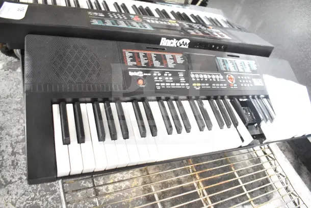 Seven keyboards, including Rock Jam RJ640 and Casiotone LK-S250, in used condition, on display.
