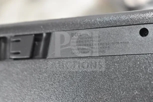 Close-up of a Dell keyboard label showing model KB212-B. Text details in various languages.