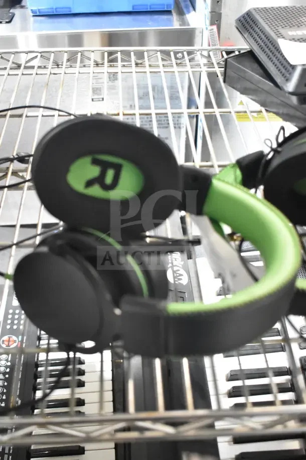 Two black and green headphones on a wire rack, featuring an "R" label for right ear.