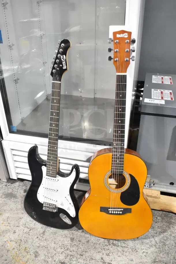 Two Rock Jam guitars: a black electric guitar with a white pickguard and a natural wood acoustic guitar. Both in good condition.