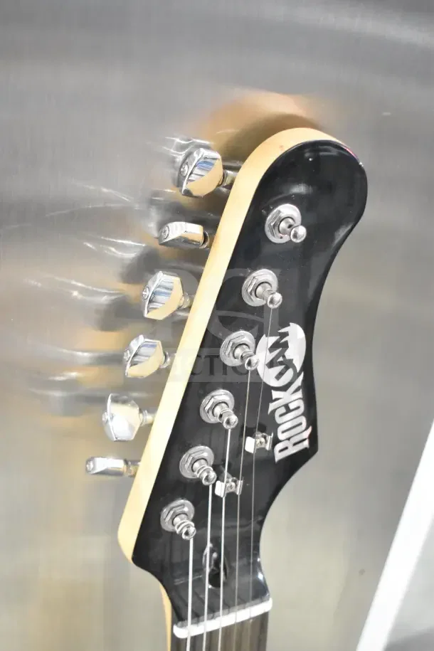 Headstock of Rock Jam guitar with chrome tuning pegs and Rock Jam logo. Black finish, excellent condition.