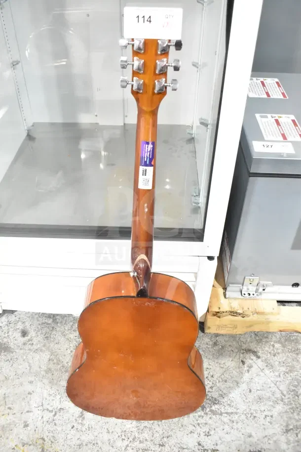 Brown Rock Jam guitar back view with chrome tuners, label indicating lot number. Appears gently used.