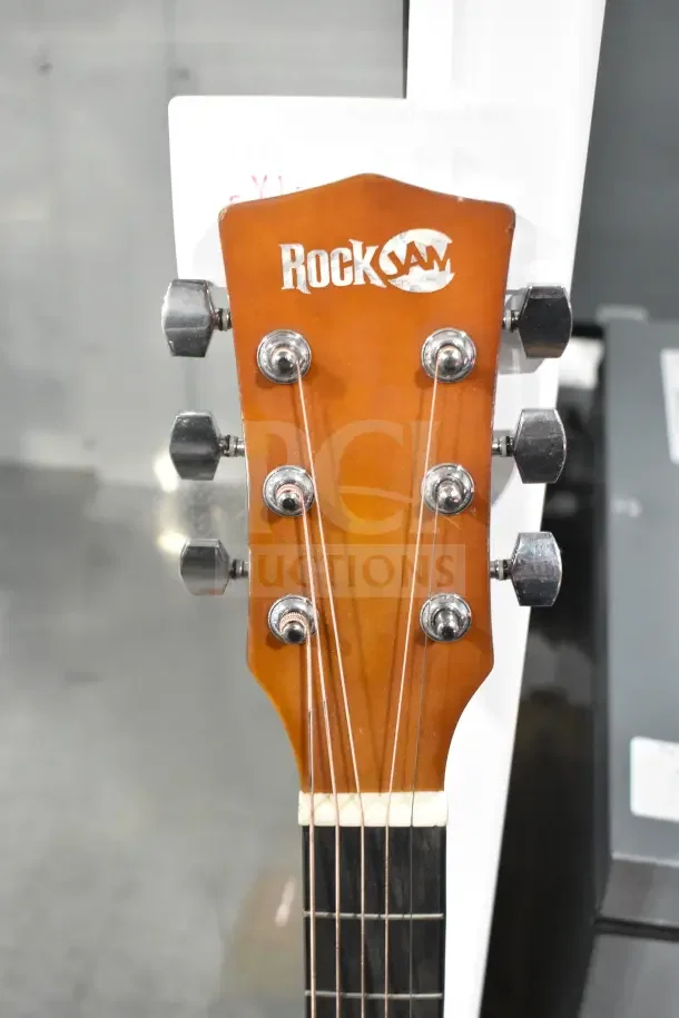 Rock Jam guitar headstock with tuning pegs, logo visible. Auction includes two of these guitars, doubling your bid's value.