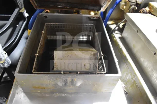 Henny Penny 600 commercial pressure fryer with stainless steel basket, used condition. 80,000 BTU, on commercial casters.