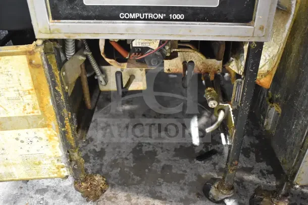 Henny Penny 600 floor-style pressure fryer, natural gas, 80,000 BTU, on commercial casters. Visible wear and rust.
