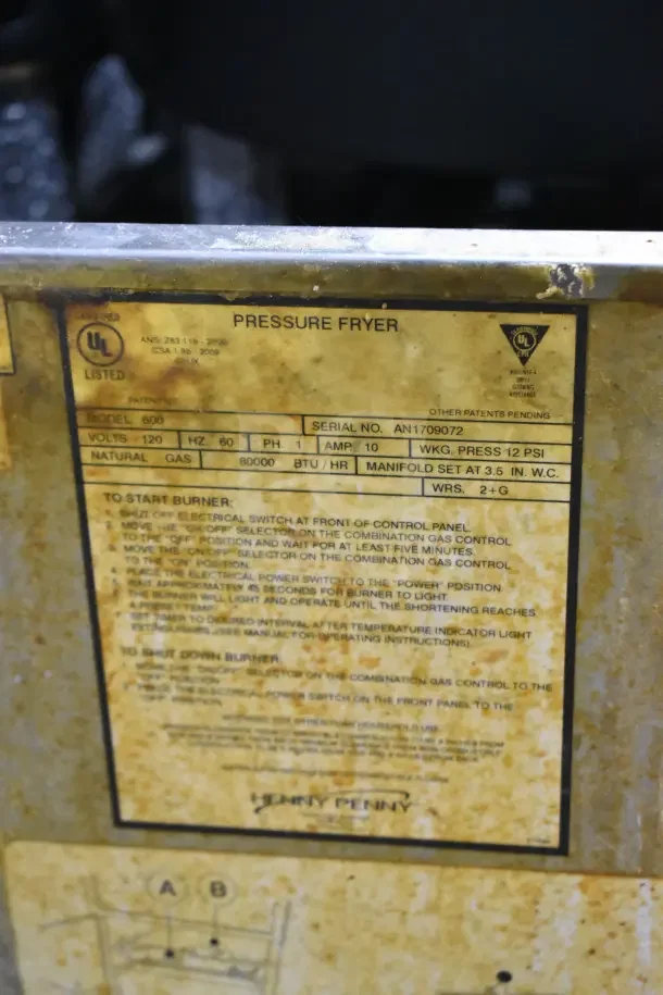 Henny Penny 600 pressure fryer label, natural gas powered, 80,000 BTU, commercial use, UL listed, on casters.